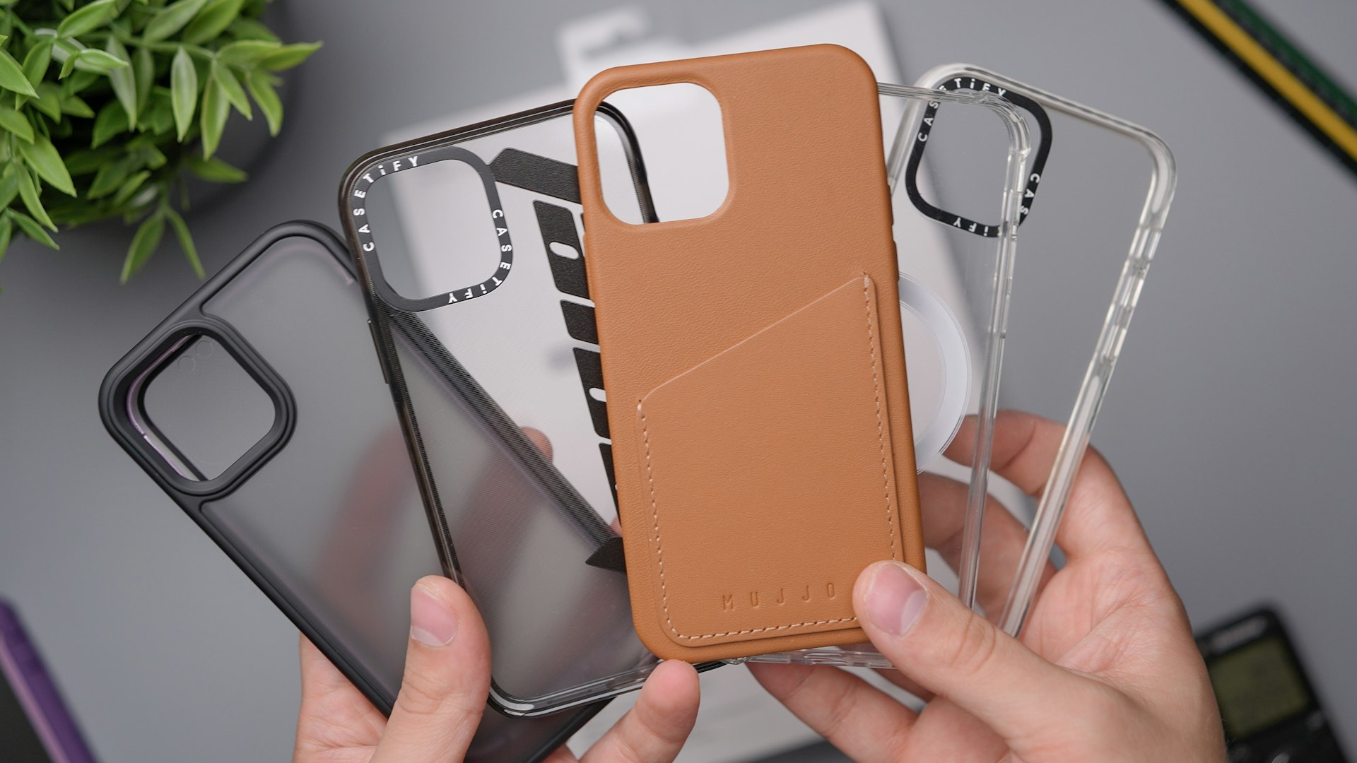 person holding orange leather smartphone case